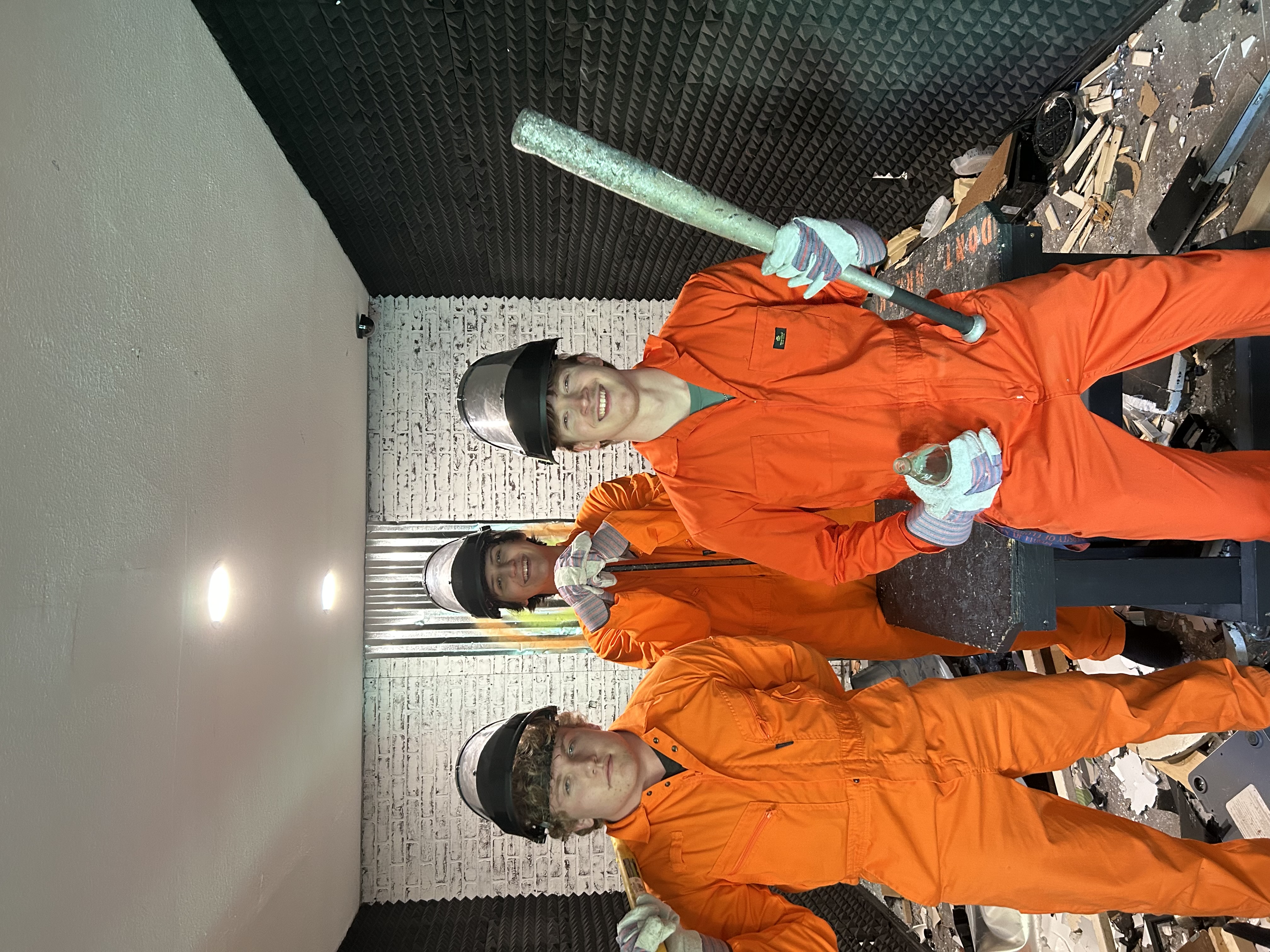 Three Crash Out customers celebrating inside the smash room after their session